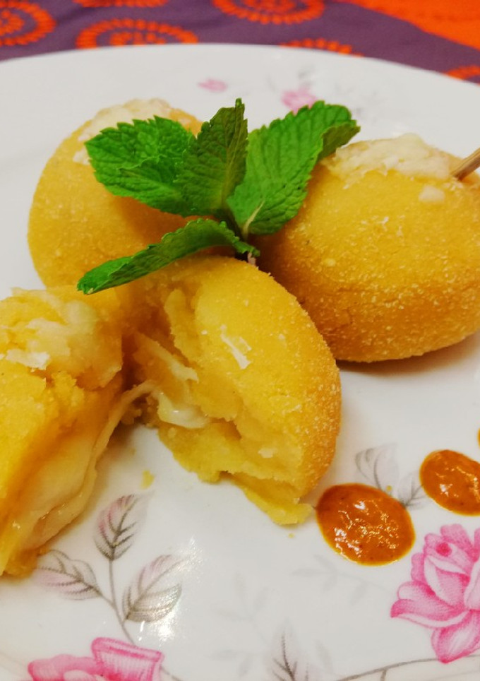 Una foto de Bombas de patata al mojo picón rellenas de queso, al horno