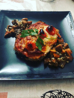 Una foto de Milanesa de berenjena a la napolitana con bolets al ajillo de guarnición