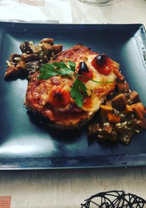Una foto de Milanesa de berenjena a la napolitana con bolets al ajillo de guarnición