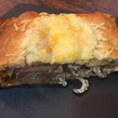 Una foto de Hojaldre relleno de secreto, queso de cabra y cebolla caramelizada
