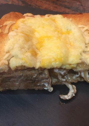 Una foto de Hojaldre relleno de secreto, queso de cabra y cebolla caramelizada