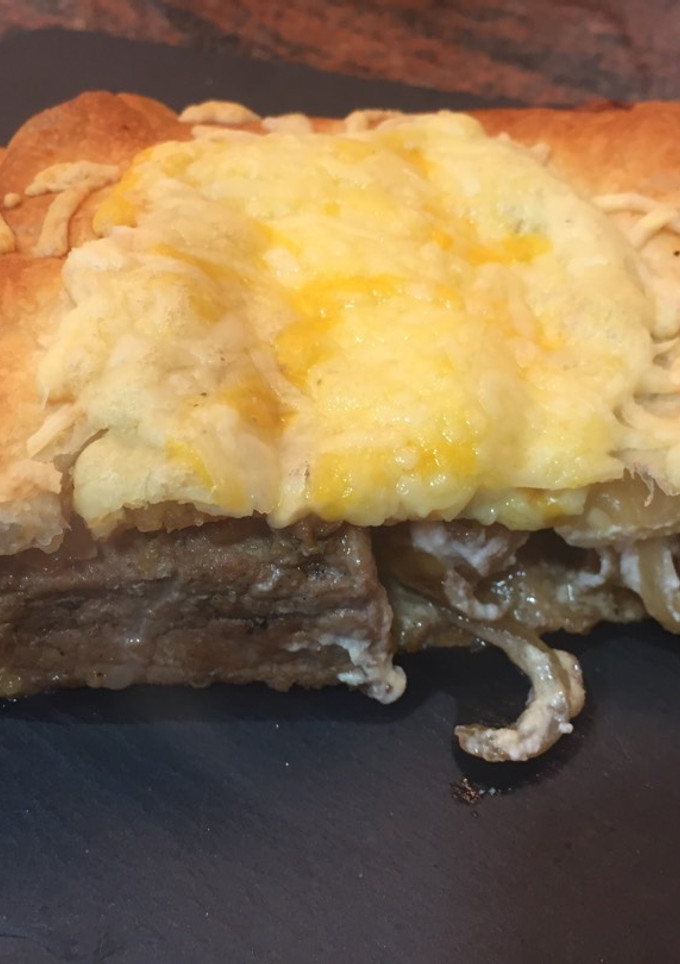 Una foto de Hojaldre relleno de secreto, queso de cabra y cebolla caramelizada