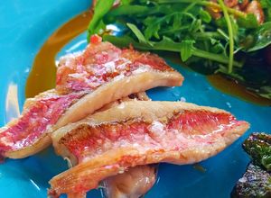Una foto de Salmonete con Tomatito kumato y rúcula