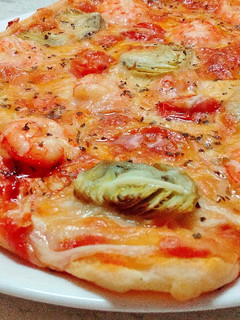 Una foto de Pizza de alcachofa y langostinos