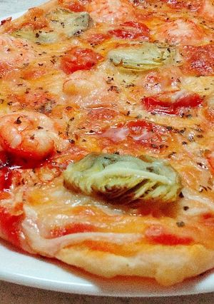 Una foto de Pizza de alcachofa y langostinos