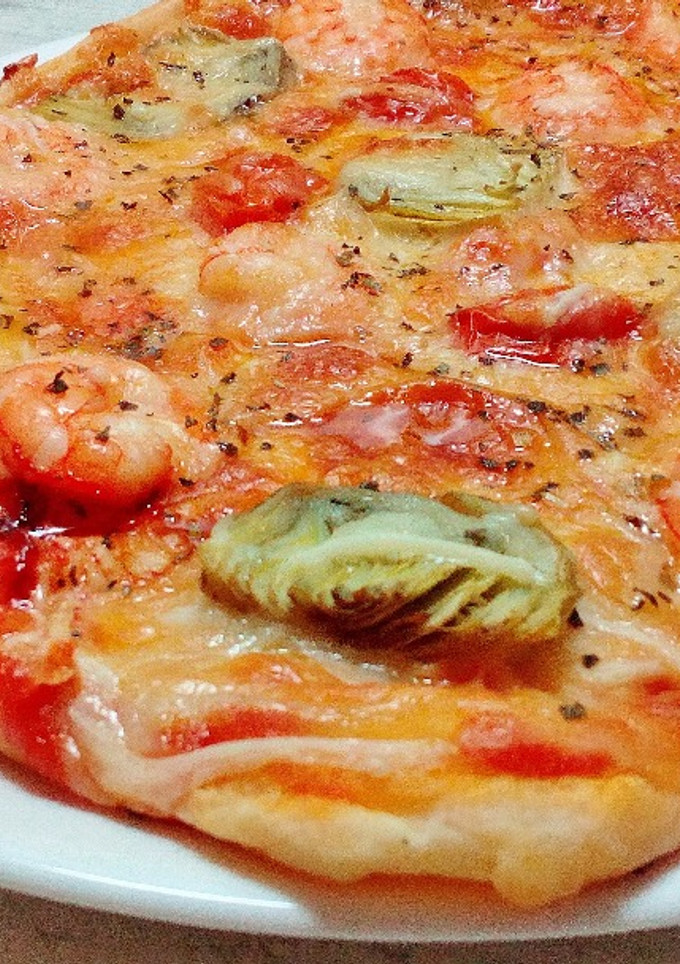 Una foto de Pizza de alcachofa y langostinos