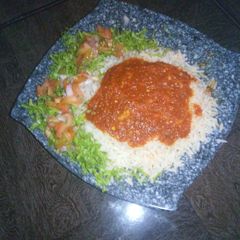 A picture of Rice and stew with lettuce salad.