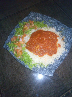 A picture of Rice and stew with lettuce salad.