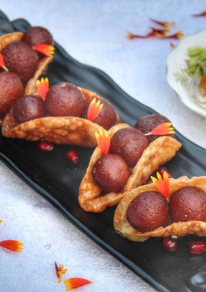 A picture of Warm gulab jamun in sweet crunchy tacos.
