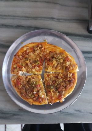 A picture of Onion tomato corn pizza.