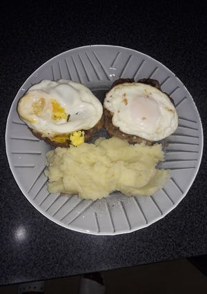 Una foto de Hamburguesas casera al plato con puré de papas y huevos fritos