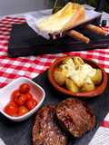 Cena suiza de Raclette de queso y patatas con hamburguesas al grill