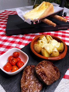 Una foto de Cena suiza de Raclette de queso y patatas con hamburguesas al grill