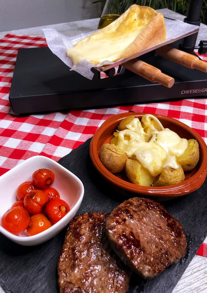 Una foto de Cena suiza de Raclette de queso y patatas con hamburguesas al grill