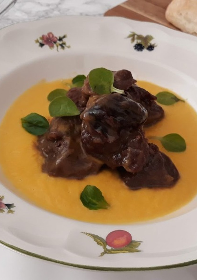 Una foto de Ternera con ciruelas sobre crema de calabaza