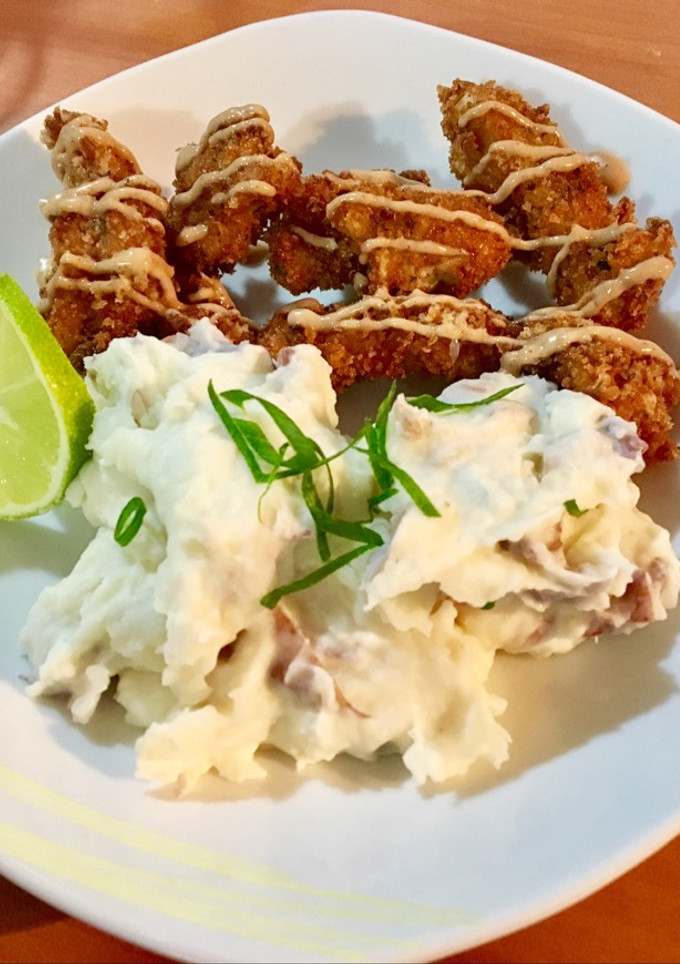 Una foto de Tiritas de Pollo Empanado acompañado de Majado De Papas Rojas
