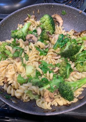 A picture of Fusilli with broccoli, arugula and mushrooms.