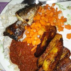 A picture of Rice with fried plantain,carrots and fried fish.