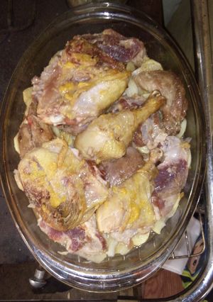 Una foto de Pollo y pulpa de cerdo al horno con base de papas y cebollas
