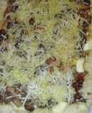 Pizza con los bordes rellenos de queso con gurumelos pollo y beicon con salsa barbacoa