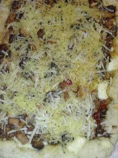 Una foto de Pizza con los bordes rellenos de queso con gurumelos pollo y beicon con salsa barbacoa