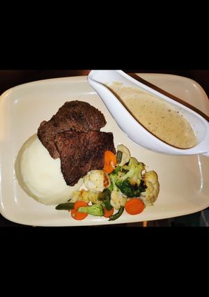 A picture of Easy mash potato with steak, white sauce and mixed vegetables.