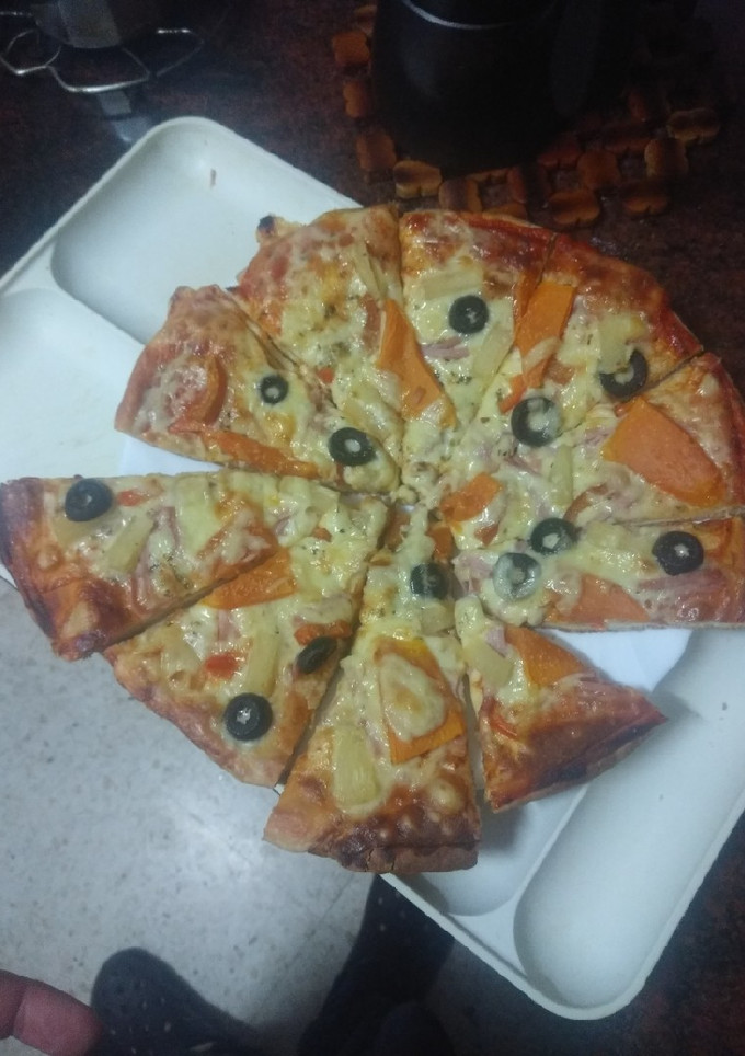 Una foto de Pizza hawaiana con papaya y piña