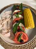 Ensalada de tomate con mozzarella con pavo y mazorca de maíz