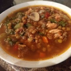 A picture of Spicy chicken, lentil, kale soup.