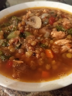 A picture of Spicy chicken, lentil, kale soup.