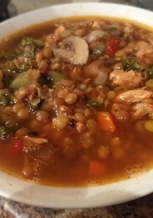A picture of Spicy chicken, lentil, kale soup.