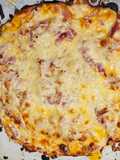 UNA Magnífica pizza con base de pollo con bacon jamón cocido y queso