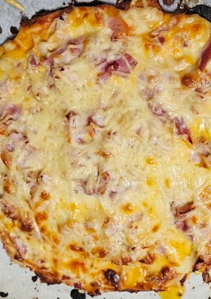 Una foto de UNA Magnífica pizza con base de pollo con bacon jamón cocido y queso