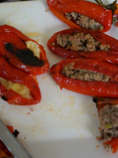 Una foto de Chile jalapeño rojo rellenos de picadillo, frijoles refritos negros con chorizo, papa con plátano y requesón