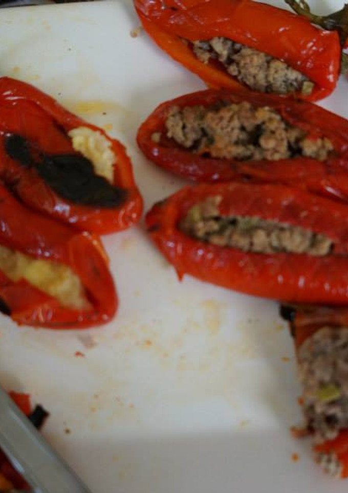 Una foto de Chile jalapeño rojo rellenos de picadillo, frijoles refritos negros con chorizo, papa con plátano y requesón