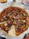 Pizza de masa de coliflor con verduras, jamón York y queso