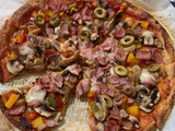 Pizza de masa de coliflor con verduras, jamón York y queso