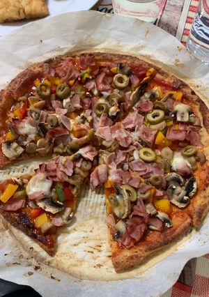 Una foto de Pizza de masa de coliflor con verduras, jamón York y queso