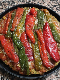 Una foto de Pizza vegana con base de avena y chía y zanahoria con guarnición