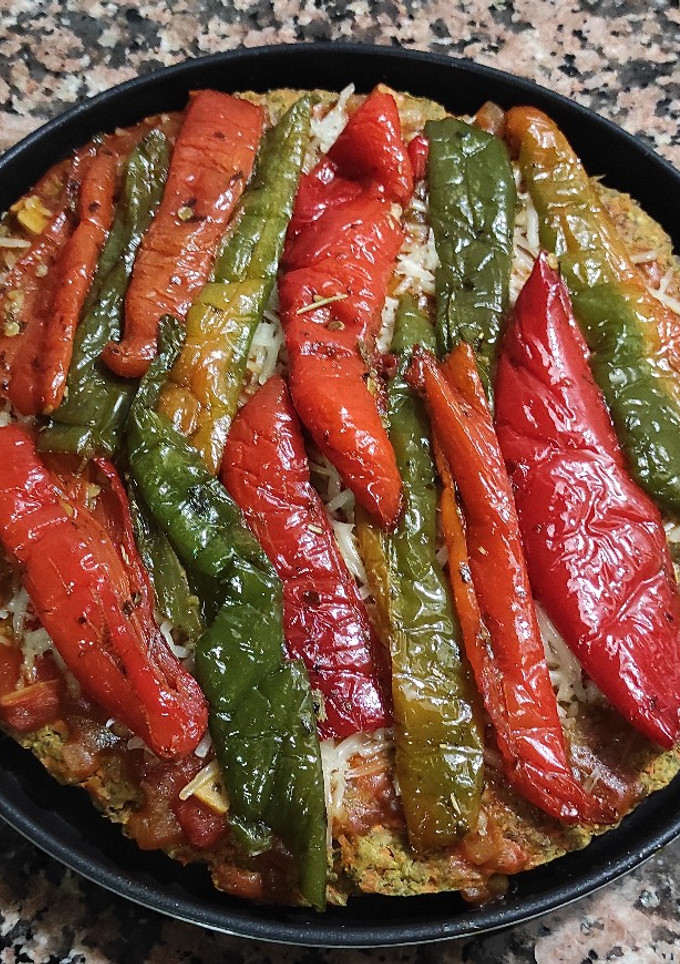 Una foto de Pizza vegana con base de avena y chía y zanahoria con guarnición