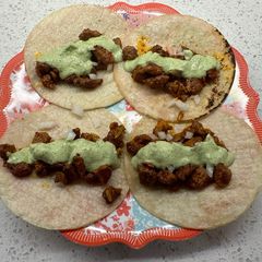 A picture of Tacos al pastor con crema de cilantro y jalapeño.
