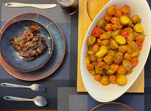 Una foto de Asado de tira en vino tinto con papas de colores al horno