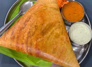A picture of South Indian dosa with coconut chutney sambhar.