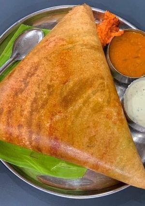 A picture of South Indian dosa with coconut chutney sambhar.