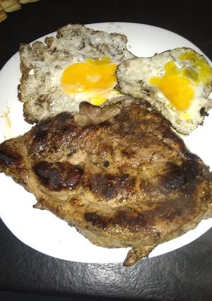 Una foto de Paleta de cerdo a la plancheta con ajo y huevo frito