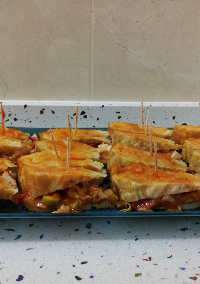 Una foto de Pincho de tortilla en tosta de atún con pimientos
