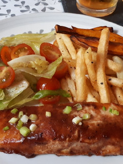 Una foto de Salmón jerk con chips y ensalada