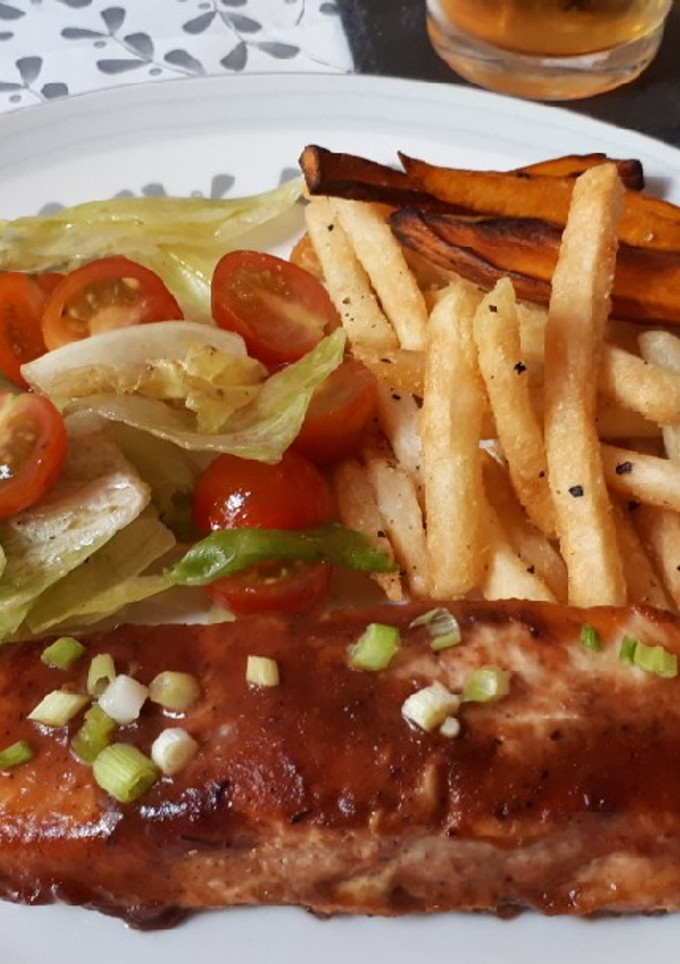 Una foto de Salmón jerk con chips y ensalada