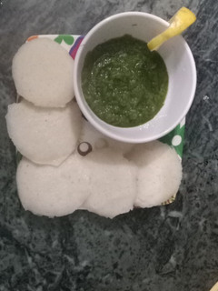 A picture of Idli with Green chutney.