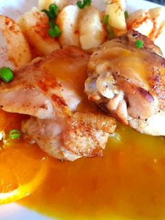 Una foto de Muslo corto de pollo con salsa de naranja y papas. 🍊